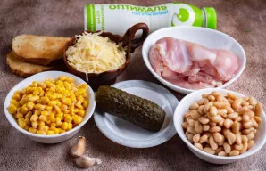 Nupilkite skystį iš pupelių ir kukurūzų skardinių. Vištienos krūtinėlę nuplaukite šaltu vandeniu. Česnaką nulupkite. Duonos skrebučius iš...