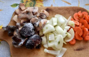 Paruoškite daržoves ir grybus. Supjaustykite grybus, svogūną ir morką ne plonais griežinėliais.