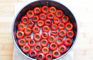 Iš spanguolių specialiu įrankiu pašalinkite sėklas. Į kepimo formą, išklotą kepimo popieriumi, sudėkite pusę uogų. Pabarstykite vienu šau...