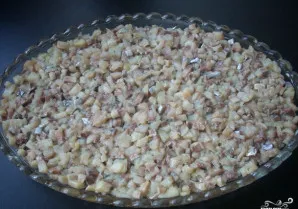 Silkės filė supjaustome mažais kubeliais ir dedame į salotinės dugną.