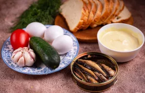 Patogu iš karto sudėti visus reikalingus ingredientus ant stalo. Atidarykite šprotų skardinę ir nupilkite aliejų. Česnako skilteles nulup...