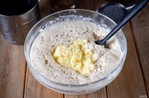 Tuomet po truputį persijokite miltus ir pradėkite minkyti tešlą – iš pradžių šaukštu, vėliau rankomis.