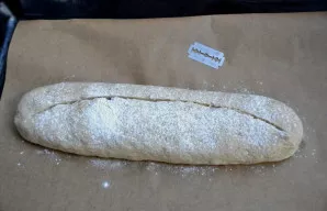 Perkelkite duoną ant kepimo skardos, lengvai pabarstykite miltais, padarykite įpjovą. Įkaitinkite orkaitę iki 250 laipsnių „viršus-apačia...