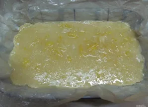 Kartu su kepimo popieriumi perkelkite tešlą į kepimo formą ir tolygiai paskirstykite citrininį įdarą.