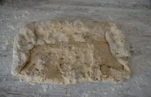 Formuokite duoną norimos formos, pavyzdžiui, batono. Tam viršutinę tešlos kraštą užlenkite link savęs, užlenkite šonus ir gerai sujunkite.