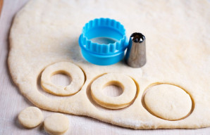 Ant darbinio paviršiaus kočėlu iškočiokite pakilusią tešlą į maždaug 0,5-0,7 cm storio lakštą. Naudokite dvi skirtingo skersmens apvalias...