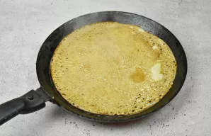 Kai blyno kraštai apskrus, paviršius taps matinis ir pasidengs skylutėmis, apverskite blyną ir apkepkite iš kitos pusės.