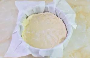 Tešlą padalinkite į 2 nelygias dalis. Didesniąją dalį paskirstykite kepimo formos dugne, suformuodami kraštelius.