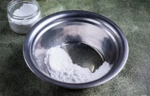 Dabar greitai paruoškite glajų. Į atskirą dubenį įdėkite kiaušinio baltymą ir suberkite cukraus pudrą.