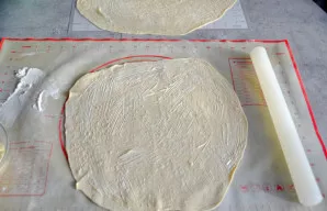 Tą patį padarykite su likusiais trimis tešlos gabalais - iškočiokite lakštus ir sudėkite juos vieną ant kito. Viršutinį lakštą taip pat p...