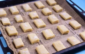 Kepimo skardą išklokite kepimo popieriumi ir sudėkite visus Pavlovsko sausainių ruošinius. Kiekvieno sausainio paviršių silikoniniu teptu...