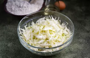 Sudėkite supjaustytus kopūstus į dubenį, įberkite druskos ir gerai paminkykite rankomis.