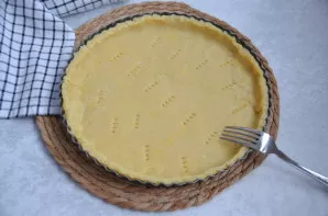 Perkelkite tešlą į formą, suformuokite nedidelius kraštelius. Dugną subadykite šakute.