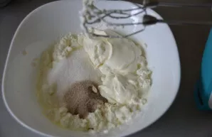 Varškę, cukrų (100 gramų), grietinę ir vanilinį cukrų išplakite mikseriu.