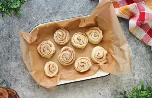 Kepimo skardą išklokite kepimo popieriumi ir lengvai patepkite sviestu. Tešlą susukite į vyniotinį, užspauskite siūlę ir supjaustykite jį...