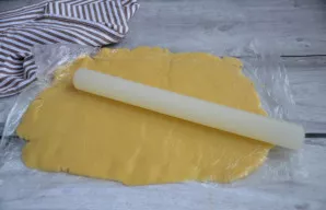 Iškočiokite tešlą į lakštą. Patarimas: tešlą patogu kočioti tiesiai maišelyje, po to ją perpjauti ir išimti tešlą.