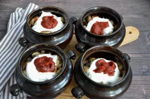 Į kiekvieną puodelį įdėkite po 1 šaukštą grietinės ir po 1 arbatinį šaukštelį pomidorų pastos.