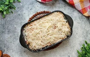 Kietąjį sūrį sutarkuokite vidutine tarka. Ištraukite formą ir pabarstykite viršų sūriu.