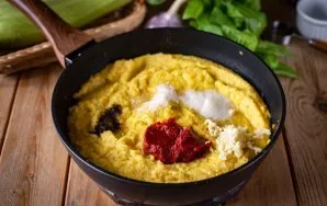 Į keptuvėje esantį daržovių mišinį įpilkite pomidorų pastos, maltų juodųjų pipirų, druskos, cukraus ir per presą išspauskite česnako skil...
