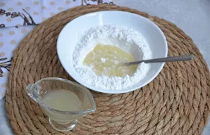 Pirmiausia į cukraus pudrą supilkite apelsinų sultis, išmaišykite, o tada po truputį įpilkite citrinos sulčių ir maišykite, kol gausite t...