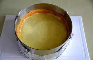 Išimkite formą iš šaldytuvo, supilkite sūrio masę ir išlyginkite paviršių.