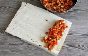 Formuokite ritinėlius. Nuo krašto palikite šiek tiek vietos, ant lavašo lakšto dėkite 3 šaukštus įdaro.