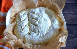 Šiek tiek pabarstykite tešlos paviršių miltais ir padarykite įpjovas aštriu peiliu arba skustuvu, kad garai kepimo metu galėtų išeiti.