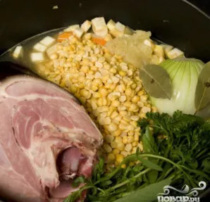 Įdėkite svogūną ir kumpį (jei reikia, kumpį supjaustykite, bet neardykite kaulo, nes kaulo sultys gali sugadinti skonį). Įdėkite žoleles.