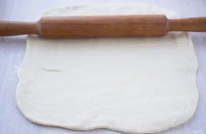 Ant tešlos tolygiai paskirstykite aguonų įdarą.