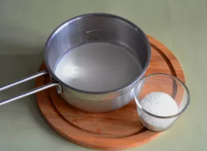 Į puodą su storu dugnu supilkite 150 g pieno, sudėkite pusę cukraus (20 g). Užvirkite.