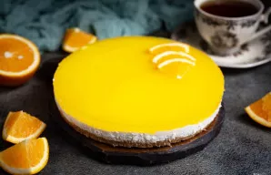 Kai apelsinų sluoksnis sustings, atsargiai išimkite sūrio pyragą iš formos ir papuoškite apelsinų skiltelėmis.