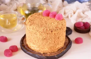 Paruoštą tortą visiškai apibarstykite smulkintomis drožlėmis – viršų ir šonus. Papuoškite pagal norą, patiekite prie stalo.