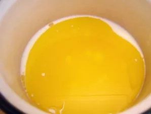 Paruošiame tešlą. Piene ištirpinkite druską ir cukrų. Įdėkite trynį, sumaišytą su 4 valgomais šaukštais augalinio aliejaus.