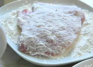 Apvoliokite kiaulieną miltuose.