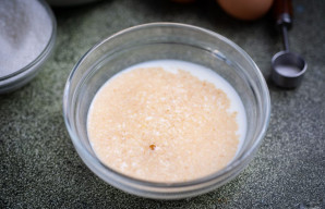 Į nedidelį dubenėlį supilkite šiltą pieną, įberkite 1 arbatinį šaukštelį cukraus ir mieles. Išmaišykite. Palikite 15 minučių pastovėti.