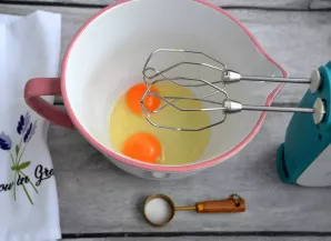 Maišymo dubenyje išplakite 2 kiaušinius su žiupsneliu druskos.