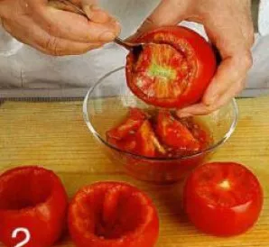 Nupjauti pomidorų viršūnes. Arbatos šaukšteliu atsargiai išimti minkštimą, stengiantis nepažeisti vaisių sienelių. Minkštimą atidėti.