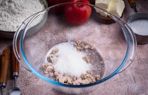 Pirmiausia paruoškite tešlą. Dideliame dubenyje pirštais sutrinkite mieles, įdėkite 1 valg. šaukštą cukraus.