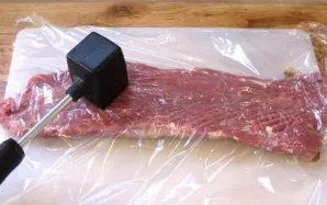 Atsargiai uždenkite mėsą maistine plėvele ir lengvai išmuškite, stengdamiesi jos nepažeisti. Šį kiaulienos vyniotinio su sūriu receptą ta...