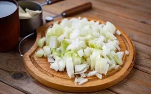 Nulupkite svogūnus ir smulkiai supjaustykite.