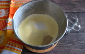 Į tešlai skirtą indą persijokite kukurūzų ir kvietinius miltus, įberkite druskos, sausų mielių, viską išmaišykite.