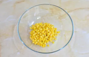 Atidarykite konservuotų kukurūzų skardinę ir nupilkite skystį. Sudėkite kukurūzus į dubenį.