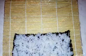 Išklokite bambukinį kilimėlį, apvyniotą maistine plėvele - taip jis nesusiteps. Ant jo patieskite nori lapą. Sudėkite ryžius ir tolygiai ...