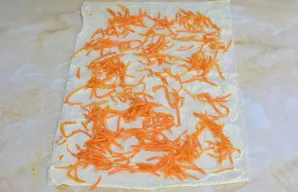 Išskleiskite lavašą ant stalo ir patepkite jį majonezu. Tolygiai paskirstykite korėjietiškas morkas.