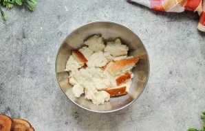 Batoną sulaužykite gabalėliais ir sudėkite į dubenį. Supilkite pieną ir išmaišykite. Palaikykite kambario temperatūroje 5 minutes.