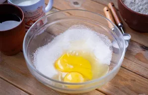 Į didelį dubenį įmuškite kiaušinius ir pridėkite druską bei visą cukrų.