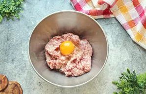 Į dubenį sudėkite mėsos faršą ir įmuškite kiaušinį.