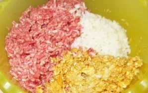 Dabar sudėkite šį mišinį į gilų dubenį, sudėkite maltą mėsą ir virtus ryžius, gerai išmaišykite.