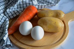 Išvirkite kiaušinius, bulves ir morką.