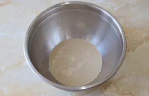 Į dubenį įpilkite šilto vandens ir augalinio aliejaus. Įberkite druskos, cukraus ir džiovintų mielių. Išmaišykite.